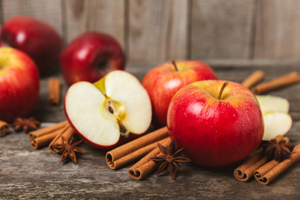 istock Apples with cinnamon on a textured wooden background. Fragrant red spiced apples with cinnamon sticks and star anise. Apple slices with spicy spices. Place for text. Copy space. Harvesting. Fruits. 2156506822