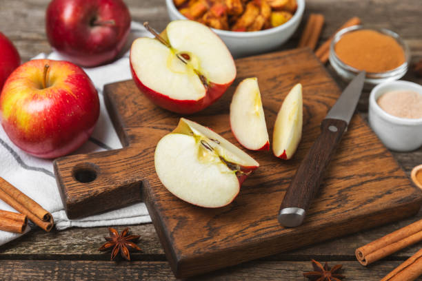 istock Apples with cinnamon on a textured wooden background. Fragrant red spiced apples with cinnamon sticks and star anise. Apple slices with spicy spices. Place for text. Copy space. Harvesting. Fruits. 2156506836