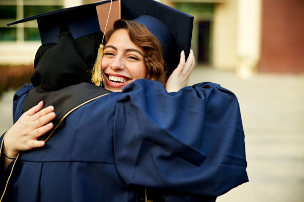 istock Happy female students embracing at graduation ceremony 2156508641