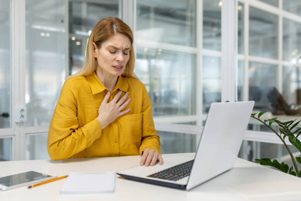 istock Woman experiencing chest pain while working on laptop in modern office 2156509418
