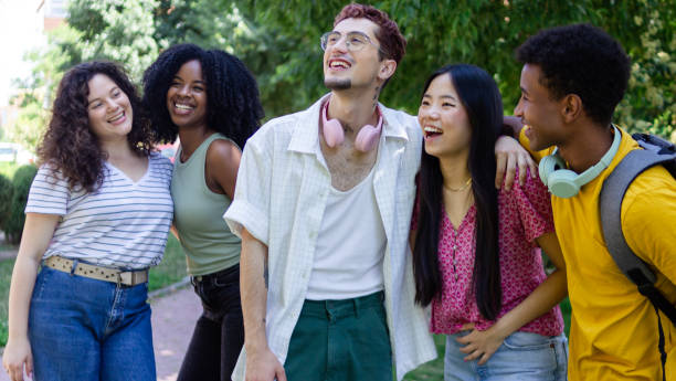 istock Group of five multiethnic young adults laughing together outdoors in a park 2156510444