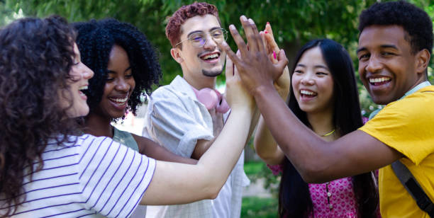 istock Group of five cheerful young students giving high five together 2156510655