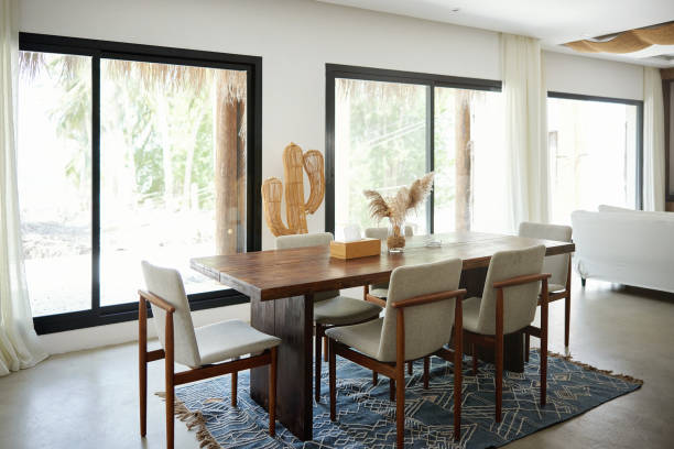 istock Wooden dining table with chairs near windows 2156513475