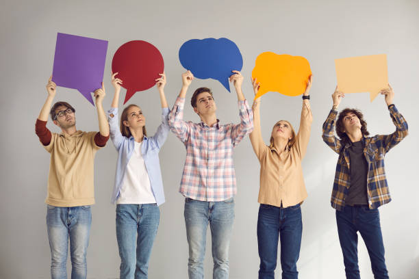 istock Group of young people holding empty speech bubbles as if expressing their opinions 2156513710