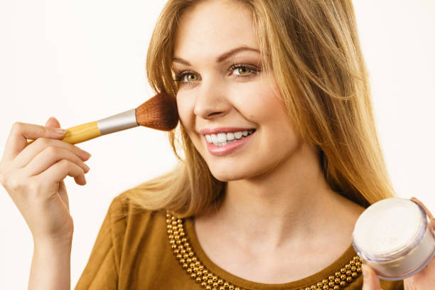 istock Smiling woman applying face powder 2156516635