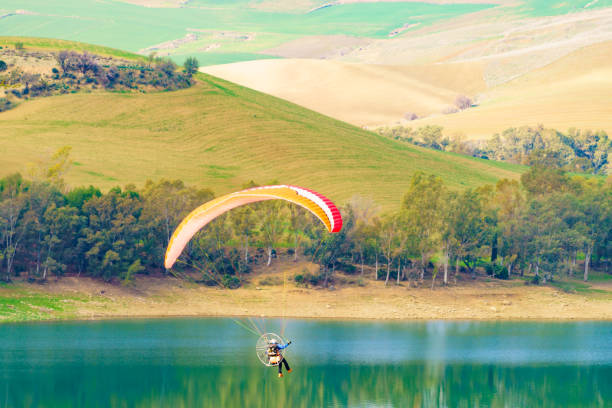 Paragliding. Paraglider flying over spanish nature landscape. Ardales Reservoir, Malaga province in Andalusia, Spain.
