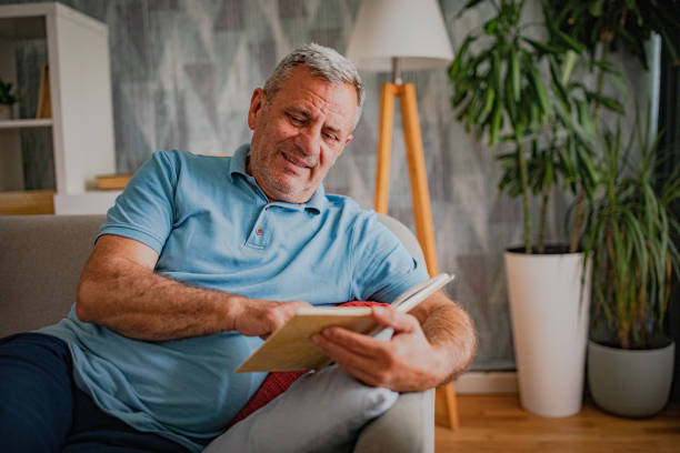 istock An elderly man is reading a book, enjoying his free time 2156517906