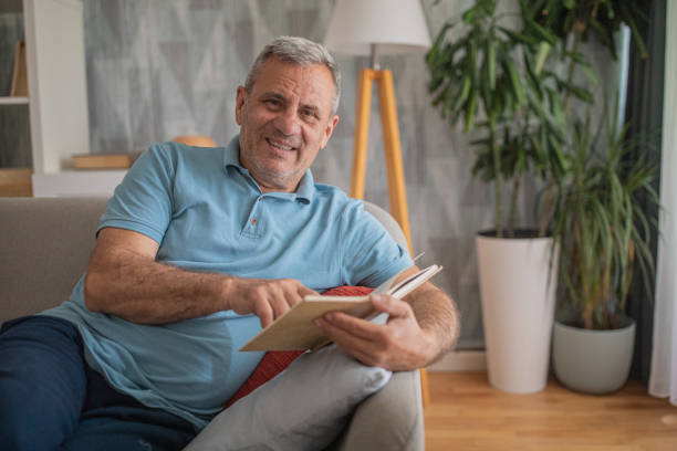 istock An elderly man is reading a book, enjoying his free time 2156518189