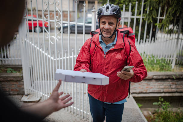 An elderly man works as a professional food delivery man