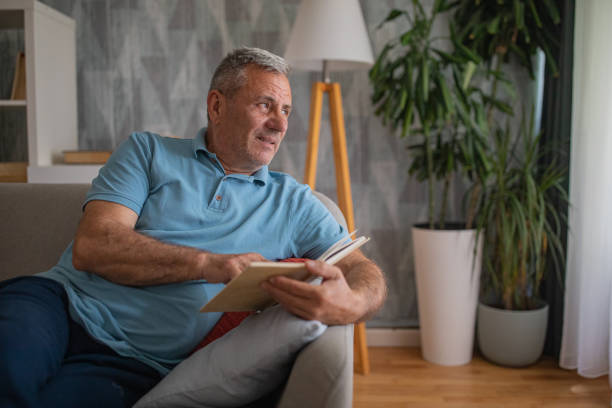 istock An elderly man is reading a book, enjoying his free time 2156518590