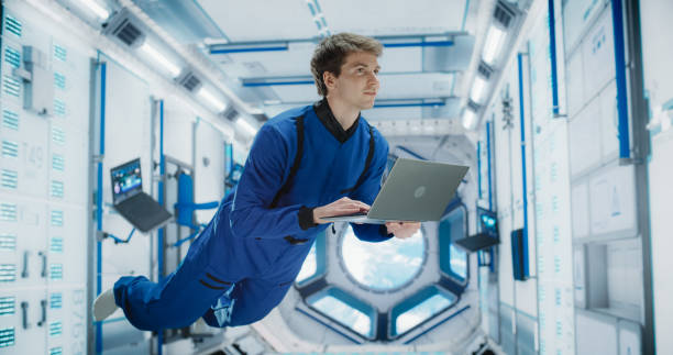 istock Male Astronaut Using a Laptop to Wirelessly Connect to a Satellite. Space Scientist Working on Computer Device Inside an Intergalactic Station. Professional Engineer Undertaking Online Service Job 2156519170
