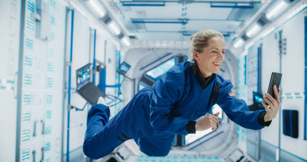 istock Caucasian Woman in Space Talking on a Phone While Flying in Zero Gravity in a Satellite. Astronaut Chatting with Mission Control, Family At Home or Work Colleagues on a Video Call App on a Smartphone. 2156520350