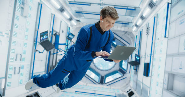 istock Caucasian Male Astronaut Using Laptop to Wirelessly Connect to a Satellite. Scientist Working on Computer Device Inside an Intergalactic Station. Professional Engineer Undertaking Service Job 2156520385