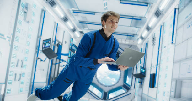 istock Caucasian Male Astronaut Using Laptop to Wirelessly Connect to a Satellite. Scientist Working on Computer Device Inside an Intergalactic Station. Professional Engineer Undertaking Online Service Job 2156520406