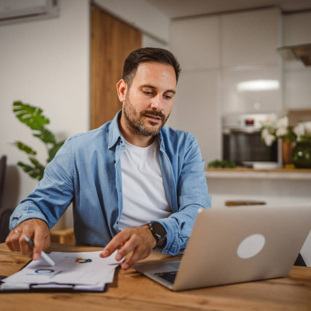 istock Adult man work form home on laptop with son at background 2156521060