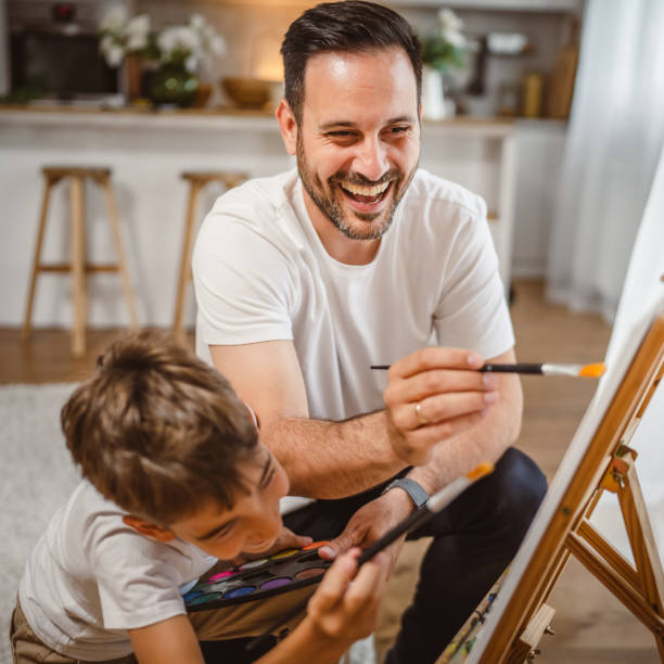istock Father and son paint together at home learn and have fun bonding time 2156521287
