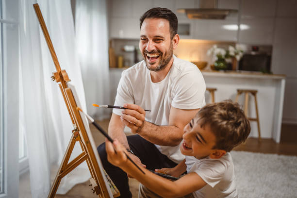 istock Father and son paint together at home learn and have fun bonding time 2156521664