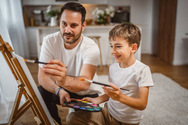 istock Father and son paint together at home learn and have fun bonding time 2156521761