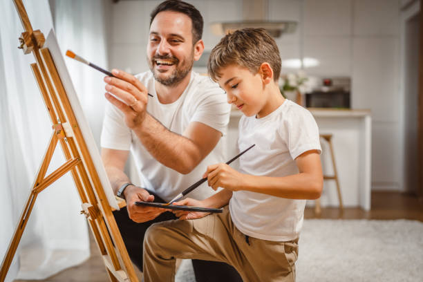 istock Father and son paint together at home learn and have fun bonding time 2156521895