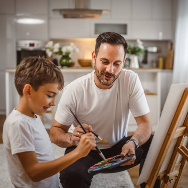 istock Father and son paint together at home learn and have fun bonding time 2156522919