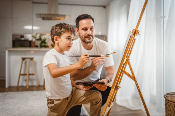 istock Father and son paint together at home learn and have fun bonding time 2156523524