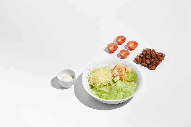 Caesar salad with bacon, capers, parmesan and croutons isolated on white (excluding the shadow)
