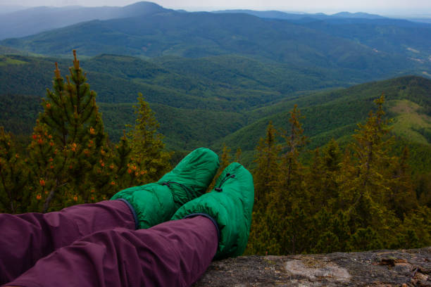 Legs in Downy booties socks  on the rock in Carpathian mountains