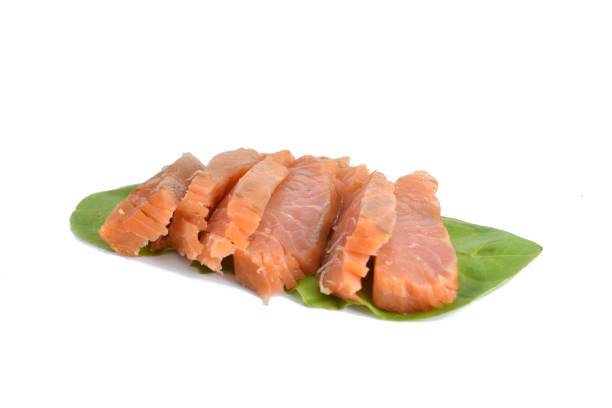 The picture shows pieces of salmon lying on lettuce leaves.