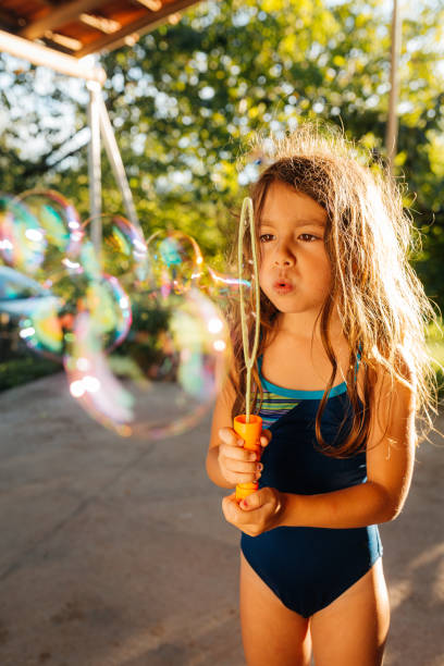 istock Girl making soap sud bubbles in the yard 2156540806