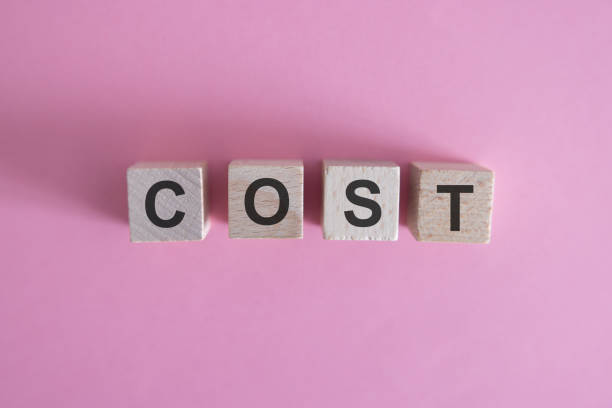 istock COST word on wooden cube block with green down arrow including copy space 2156543242