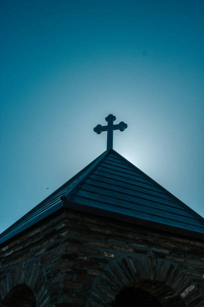 Church roof and cross with sun behind it, Udzo monastery,  Tbilisi,  Georgia