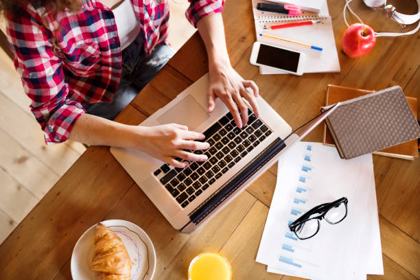 istock A beautiful university student is writing her thesis on a laptop, sitting at home on the couch. 2156548515