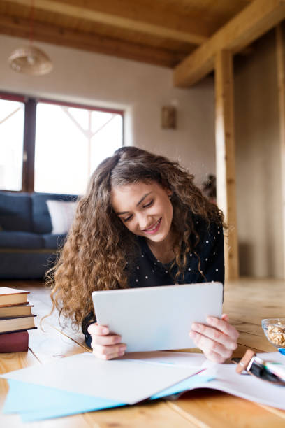 istock A beautiful university student is writing her thesis on a laptop, sitting at home on the couch. 2156548629