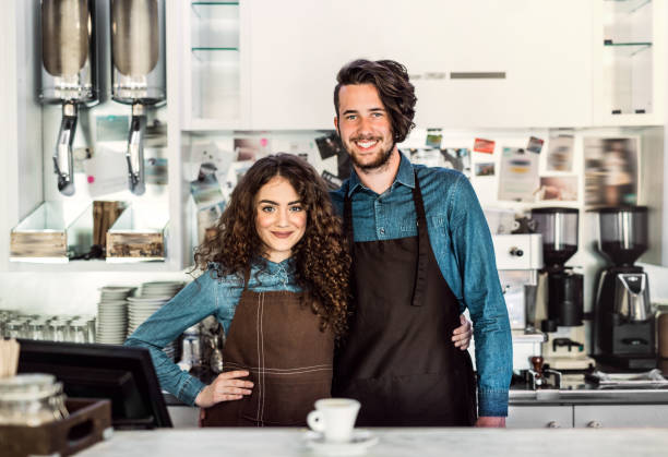 istock Two young baristas working in coffee shop, standing by counter. University students working part-time in cafe. 2156548726