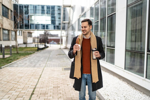 istock Businessman eating sandwich and drinking coffee 2156549033