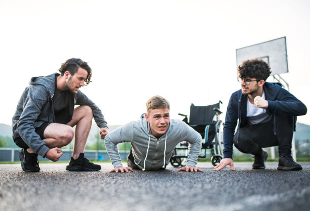 istock Disabled young man exercising with his supportive friends. Male friendship. 2156554242