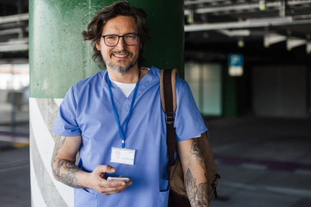 istock Doctor in uniform going home from work, standing on parking lot. looking at camera. Work-life balance of healthcare worker. 2156554337