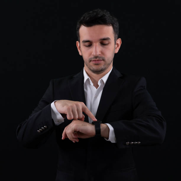 istock A Business people using smartwatch while working at the office. Close up of Hands of Businessman using Smartwatch. Black background. 2156555265