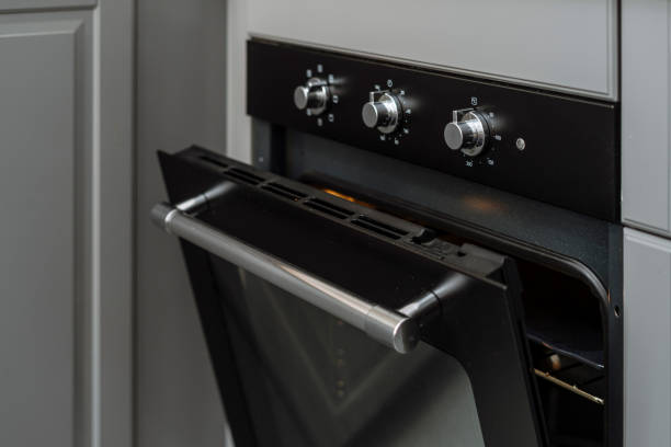 istock Electric oven with open door and control panel with knob at kitchen 2156557322