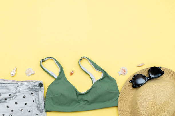 istock Travel vacation summer flat lay, accessories objects, hat, sunglasses, clothes, bathing suit, seashells on yellow background with copy space, planning trip adventure 2156558021