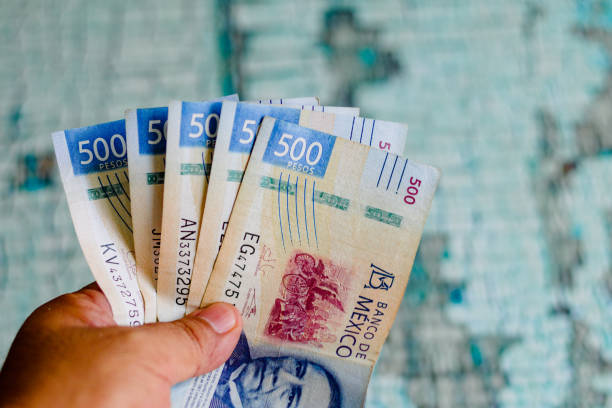 Two thousand five hundred Mexican pesos on a wooden table, banknotes