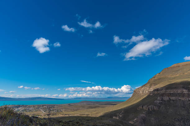 A beautiful blue sky with a few clouds and a mountain in the background. The sky is clear and the sun is shining brightly