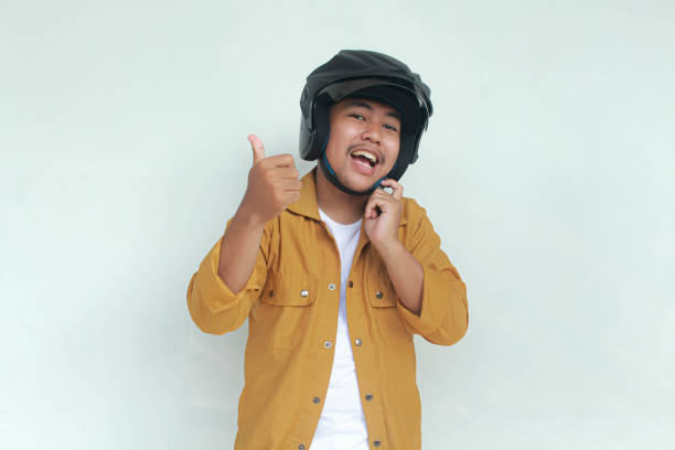 istock oung Asian man smiling and give thumb up while wear a motorcycle helmet 2156563225