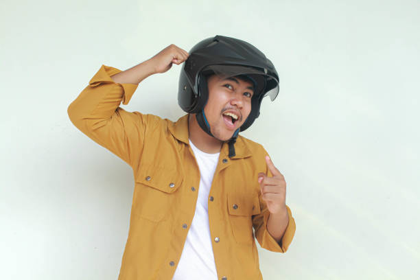 istock Young Asian man smiling and confidence gesture while wear a motorcycle helmet. 2156563236