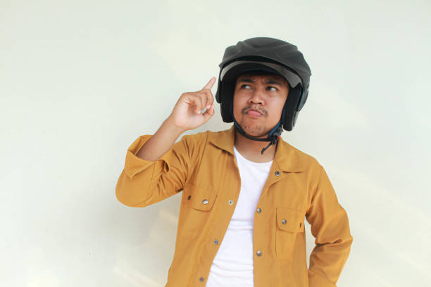istock Man with a motorcycle helmet thinking an idea 2156563288