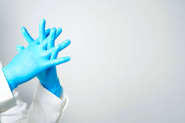 istock Doctor's hand in blue medical gloves holding an object on a white background 2156564236
