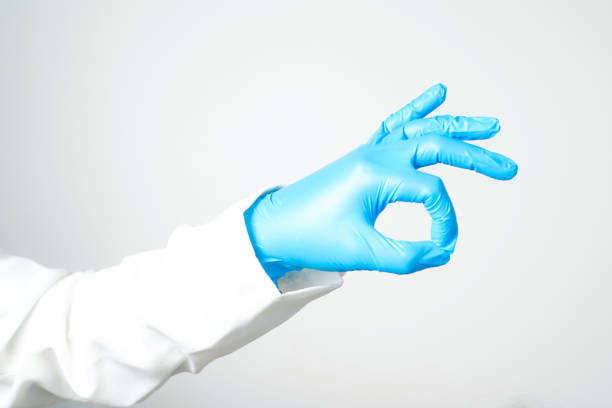 hand gestures or signs in blue disposable latex surgical gloves isolated
