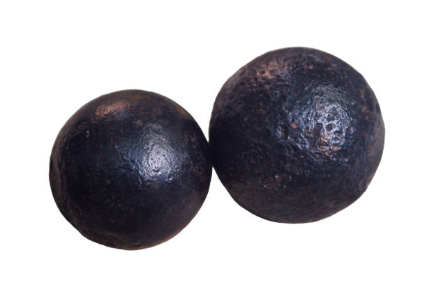 istock Two cannon ball one-pound closeup, isolated on white background. Old objects of the 18th century era, reenactment of events 2156568901