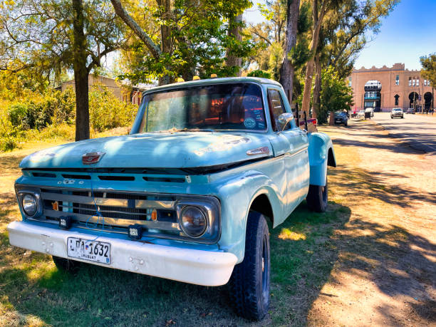 colonia del sacramento, uruguay - november 2 2022: a rusted blue colored vintage ford f-100 1960s pick up truck parked along the road