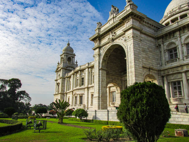 Dusit Palace of Bangkok seen from intersection of Thanon Si Ayutthaya and U Thong Nai Ally. In between is a square with equestrian statue of King Chulalongkorn. Many tourist buses are parked in square. A thai man is driving motorcycle in left foreground